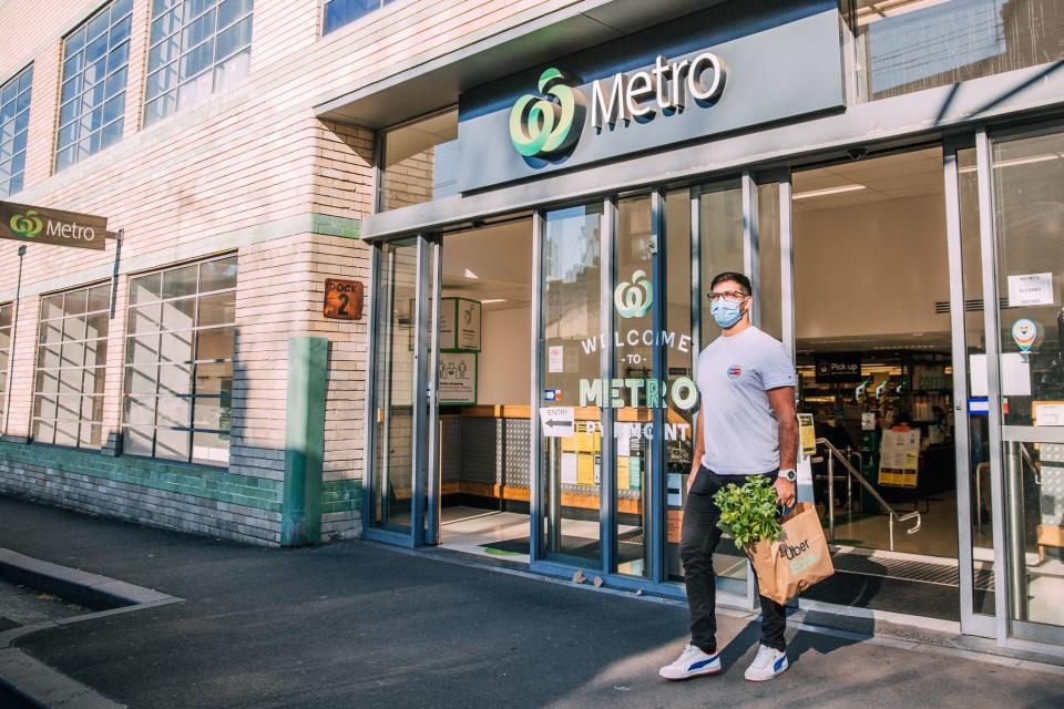 Uber Eats delivery man walking out of a Woolworths Metro store. Source: Woolworths