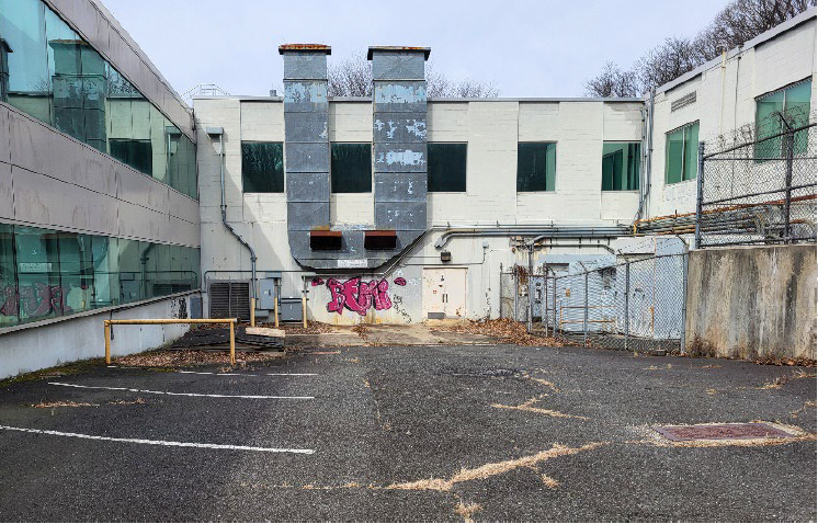 A photo of "Internal courtyard/loading area between northerly and southerly building wings, depicting vandalism and disrepair on 3/16/23" according to the township's redevelopment investigation report.