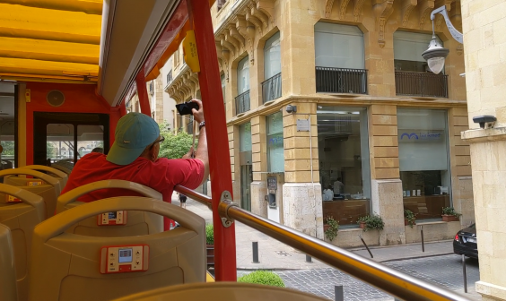 A tourist takes a picture from Beirut’s new City Sightseeing tour (Richard Hall/The Independent)