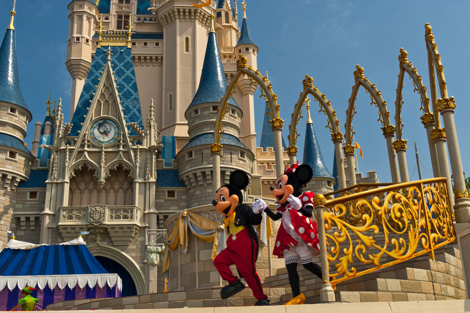 Mickey Mouse and Minnie Mouse perform in front of the Cinderella Castle, Magic Kingdom, Walt Disney World, Orlando, Florida USA