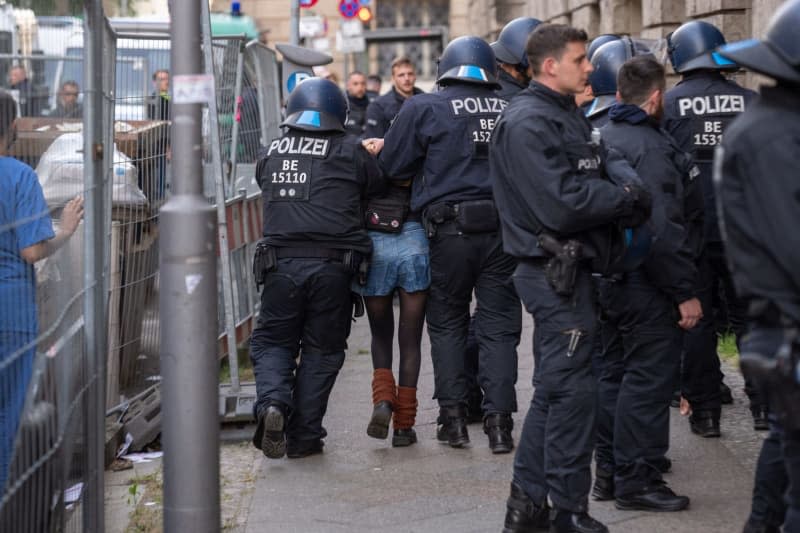 One of the pro-Palestinian occupiers of the Institute of Social Sciences at Berlin's Humboldt University (HU) is taken out of the building by police officers. Activists have occupied the university in support of the Palestinians and in protest against Israel. Christophe Gateau/dpa