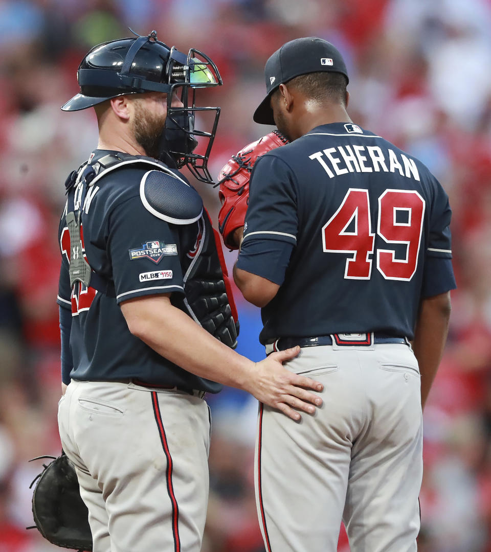 Atlanta Braves catcher Brian McCann, left, confers with pitcher Julio Teheran just before Teheran gave up a winning sacrifice fly to St. Louis Cardinals catcher Yadier Molina to score Kolten Wong during the 10th inning of Game 4 of a baseball National League Division Series, Monday, Oct. 7, 2019, in St. Louis. (Curtis Compton/Atlanta Journal-Constitution via AP)