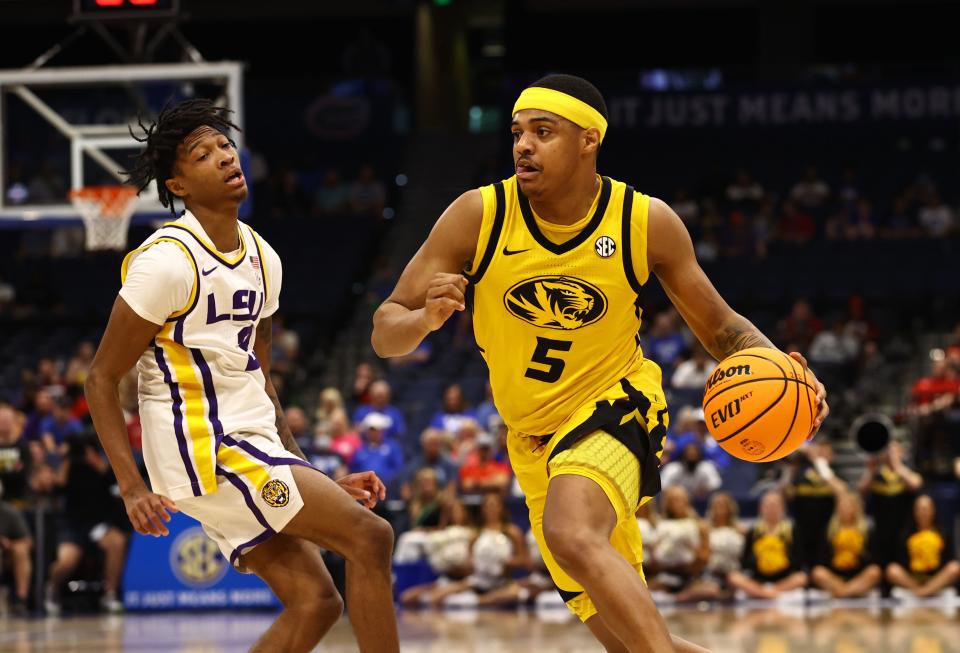 Mar 10, 2022; Tampa, FL, USA; Missouri Tigers guard Jarron Coleman (5) drives to the basket as LSU Tigers guard Eric Gaines (2) defends during the first half at Amalie Arena. Mandatory Credit: Kim Klement-USA TODAY Sports