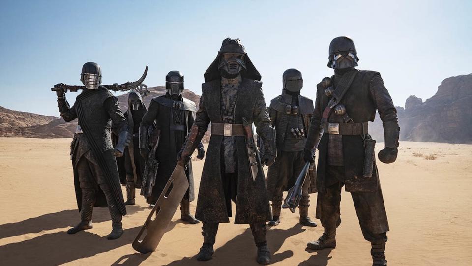 The Knights of Ren standing in the desert together like the cover of a boy band album 