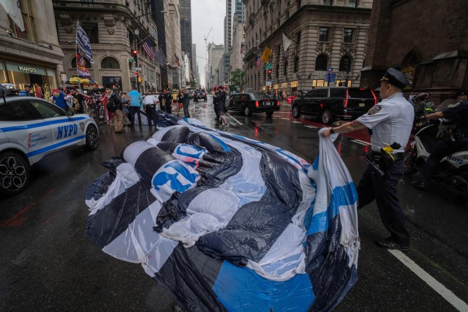 NYPD officers remove a giant Trump flag from the street as they detain those who carried it during a 'Thin Blue Trump Parade' on June 6, 2024 in New York City (Getty Images)