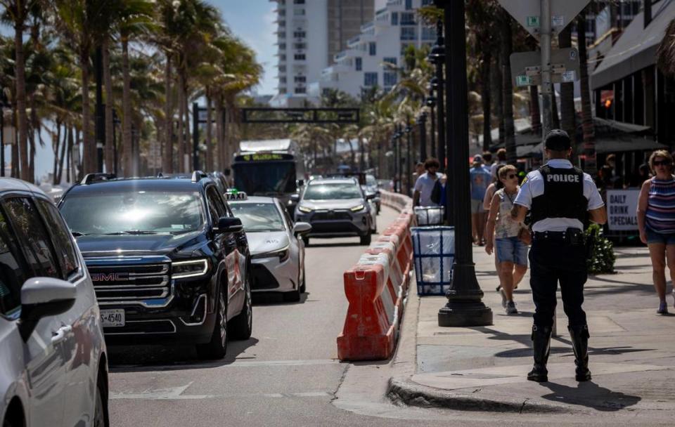 A Fort Lauderdale police officer, right, keeps an eye on traffic on A1A and Poinsettia Street on Fort Lauderdale Beach on Feb. 28, 2024, ahead of spring break.