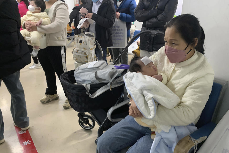 A woman tends to a child at a fever clinic at a children's hospital in Beijing, December 14, 2022. / Credit: Dake Kang/AP