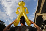 A protester holds a balloon shaped like an alien - to mock accusations that foreigners fund and direct their movement - during a rally Friday, Nov. 27, 2020 in Bangkok, Thailand. Pro-democracy demonstrators are continuing their protests calling for the government to step down and reforms to the constitution and the monarchy, despite legal charges being filed against them and the possibility of violence from their opponents or a military crackdown. (AP Photo/Sakchai Lalit)