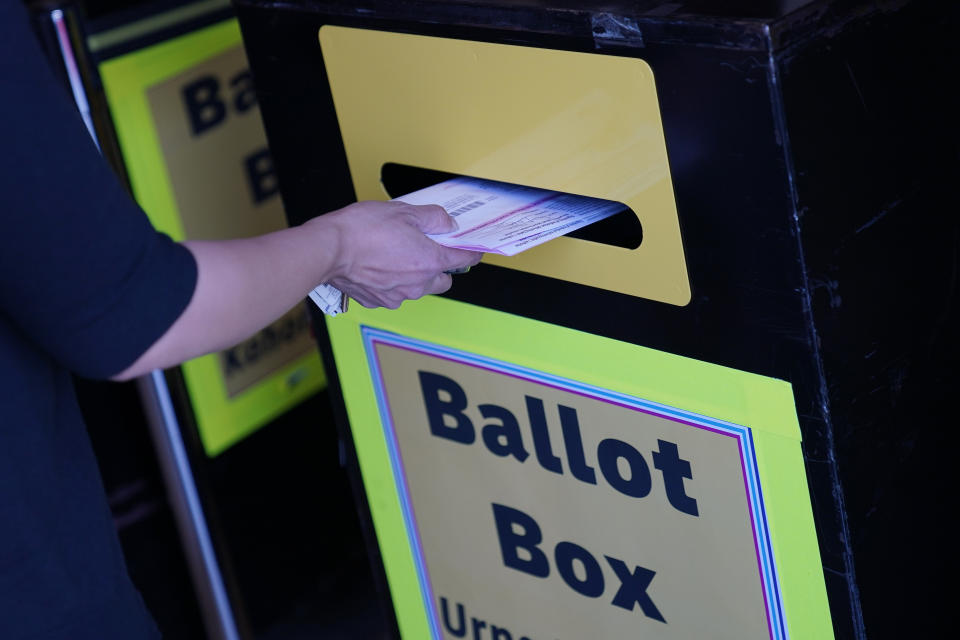 FILE - In this Oct. 29, 2020, file photo, a person places a mail-in ballot in a drop box at the Clark County Election Department in Las Vegas. As Republicans roll back access to the ballot, Democratic lawmakers have been quietly moving to expand voting rights. In Virginia, Maryland, Nevada and other states where Democrats have control, lawmakers are pushing to make it easier to cast ballots by mail, increase early voting and require greater oversight over changes to election law. (AP Photo/John Locher, File)