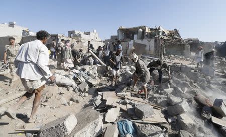 People search for survivors under the rubble of houses destroyed by an air strike near Sanaa Airport March 26, 2015. REUTERS/Khaled Abdullah