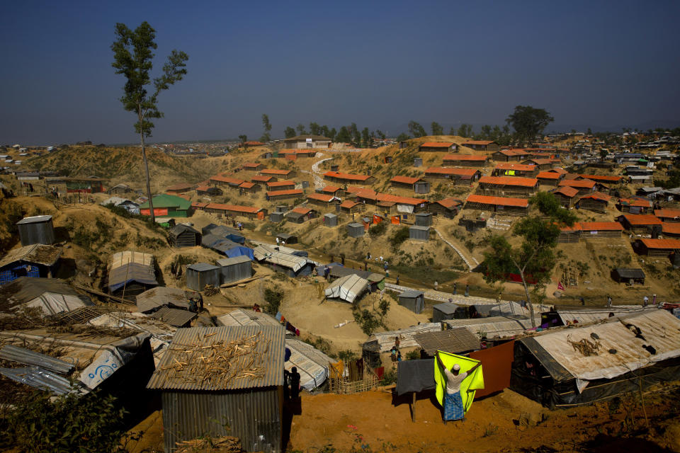 FILE - In this Jan. 23, 2018 file photo, a Rohingya refugee hangs a blanket out to dry at Balukhali refugee camp, about 50 kilometers (32 miles) from Cox's Bazar, Bangladesh. Authorities in Bangladesh said Tuesday, Oct. 22, 2019, that they want to start relocating thousands of Rohingya refugees to a Bay of Bengal island soon from crammed camps near the border with Myanmar, from where they fled. Top government administrator in Cox's Bazar, Kamal Hossain, said they listed 100 families willing to move to Bhasan Char, an island hours by boat from the mainland. The government has said it will relocate 100,000 refugees to the island in phases. (AP Photo/Manish Swarup, File)