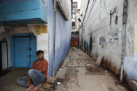 A man sits on a deserted street during fresh lockdown in Prayagraj, India, Saturday, July 11, 2020. In just three weeks, India went from the world’s sixth worst-affected country by the coronavirus to the third, according to a tally by Johns Hopkins University. India's fragile health system was bolstered during a stringent monthslong lockdown but could still be overwhelmed by an exponential rise in infections. (AP Photo/Rajesh Kumar Singh)