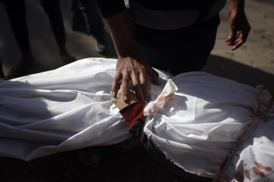 Un palestino llora sobre el cuerpo de un niño muerto en el bombardeo israelí de la Franja de Gaza, en el hospital Nasser en Jan Yunis, 22 de enero de 2024. (AP Foto/Mohammed Dahman)