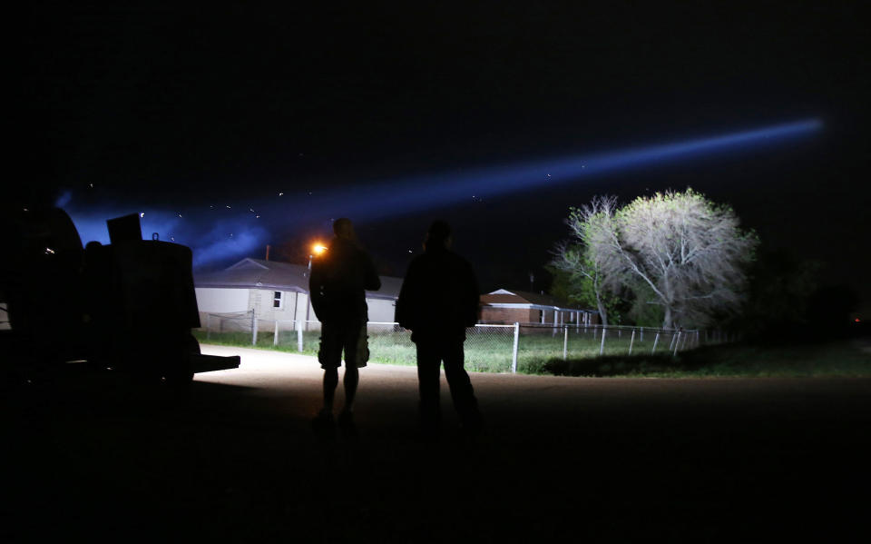 West residents watch a search light shinning near the plant site, Thursday, April 17, 2014, in West, Texas. A 4-17 Forever Forward ceremony was held across town. (AP Photo/Waco Tribune Herald, Jerry Larson)