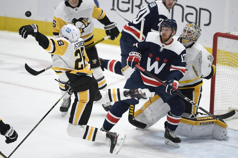 Pittsburgh Penguins defenseman Marcus Pettersson (28) reaches for the puck in front of Washington Capitals left wing Michael Raffl (17) during the second period of an NHL hockey game Saturday, May 1, 2021, in Washington. (AP Photo/Nick Wass)