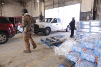 Phillips County employees distribute water for people without water Tuesday, Jan. 30, 2024, in Helena, Arkansas. Parts of the east Arkansas town has been without water for two weeks after the state was hit by below freezing temperatures, and residents have been lining up for jugs of water and a truck of mobile showers dispatched to the community. (AP Photo/Karen Pulfer Focht)