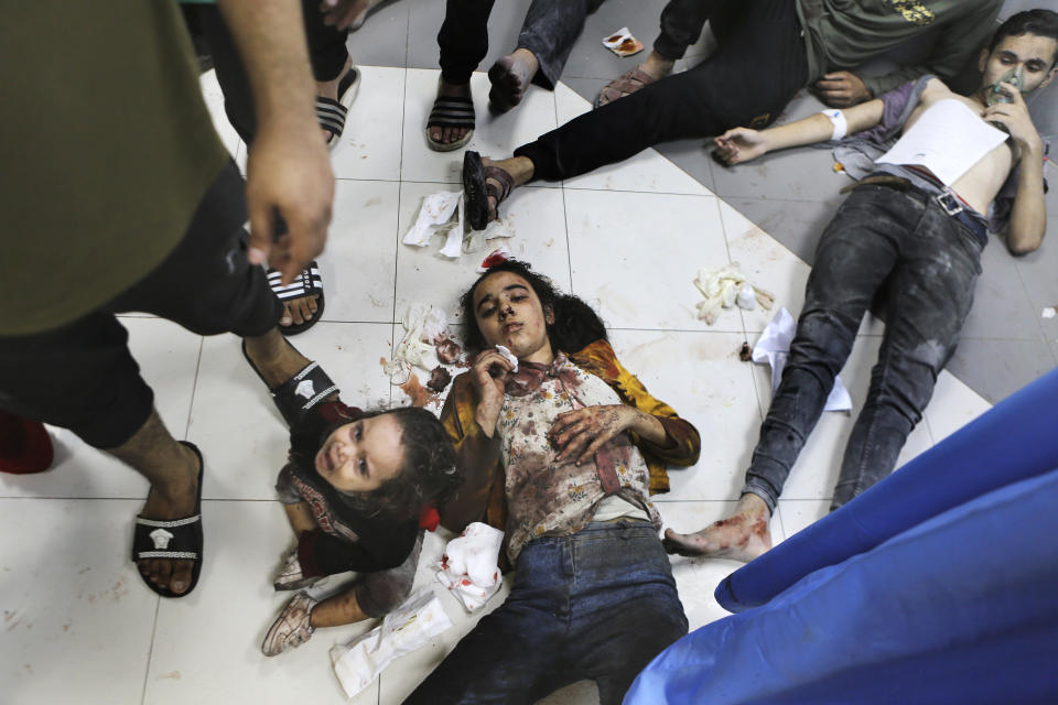 Wounded Palestinians lie on the floor at the al-Shifa hospital, following Israeli airstrikes, in Gaza City, Tuesday, Oct. 17, 2023. (AP Photo/Abed Khaled)