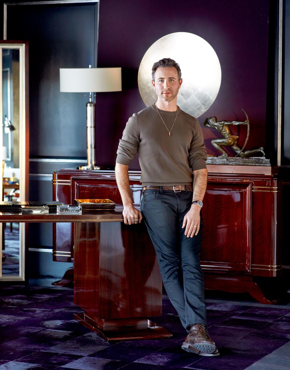 Designer Dan Fink in the office. Walnut-and-brass desk, circa 1925; 1930s sideboard; cowhide rug by Doris Leslie Blau.