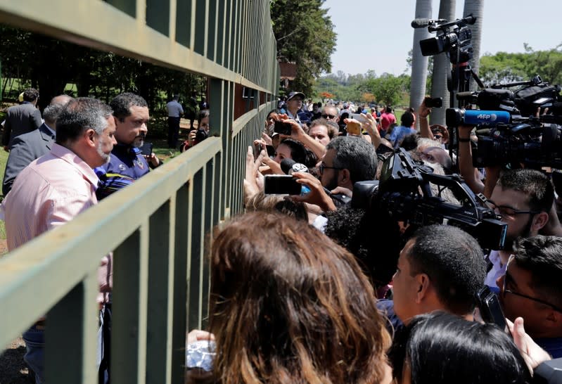 Embassy employee speaks to the journalists outside Venezuelan embassy in Brasilia