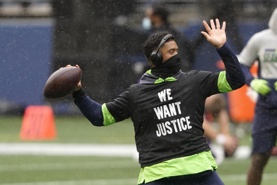 Seattle Seahawks quarterback Russell Wilson warms-up in a light rain before an NFL football game against the Minnesota Vikings, Sunday, Oct. 11, 2020, in Seattle. (AP Photo/Ted S. Warren)