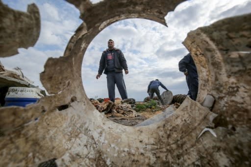 Palestinians recover what they can from the site of an Israeli air strike in the southern Gaza Strip