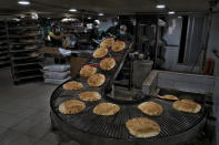 FILE - Bakery workers package freshly-produced bread coming off a production line at an automated bakery in the southern Beirut suburb of Dahiyeh, Lebanon, Tuesday, March 15, 2022. Russia’s war in Ukraine has threatened food supplies in countries like Lebanon, which has the world's highest rate of food inflation, 122%, and depends on the Black Sea region for nearly all of its wheat. The Razoni, loaded up with 26,000 tons of corn, is the first cargo ship to leave Ukraine since the Russian invasion, and set sail from Odesa Monday, August 1, 2022. Its final destination is Lebanon, with estimated arrival date on Saturday, Aug. 6, 2022. (AP Photo/Bilal Hussein, File)