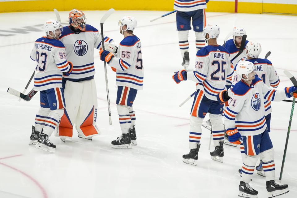Edmonton Oilers goaltender Stuart Skinner, second from left, celebrates with teammates after they beat the Dallas Stars 3-2 in double overtime in Game 1 of the NHL hockey Western Conference Stanley Cup playoff finals, Thursday, May 23, 2024, in Dallas. (AP Photo/Tony Gutierrez)