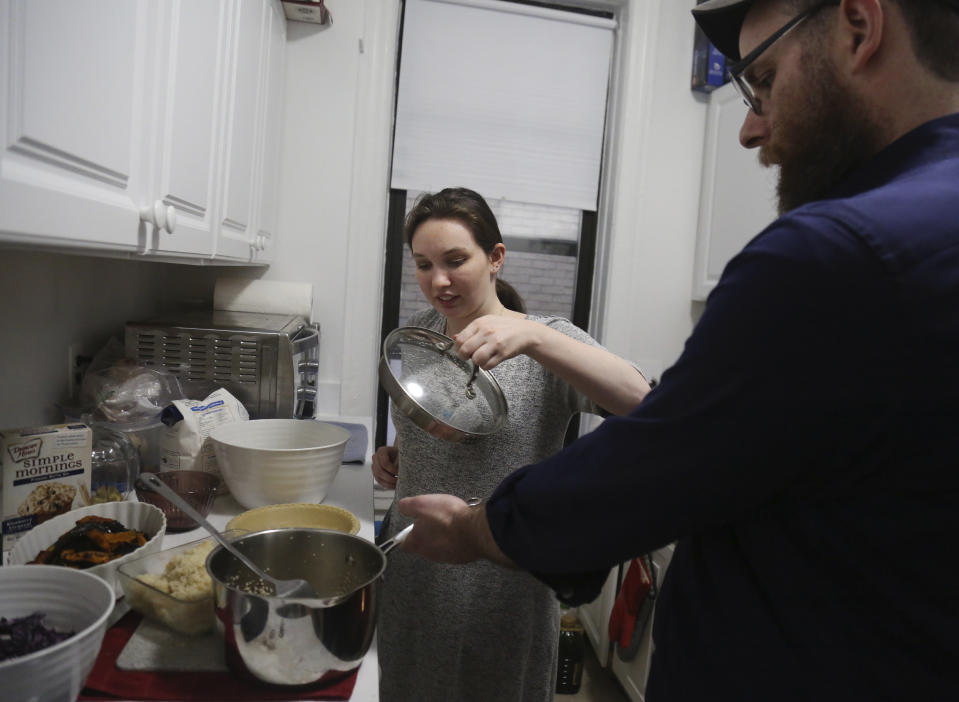 In this Friday, Jan. 3, 2020, photo, Shoshana Blum, 20, prepares Shabbat dinner with her father Rabbi Yonah Blum at their home in New York. Dinner for the family of five included butternut squash, couscous, chicken, salad and apple pie. (AP Photo/Jessie Wardarski)