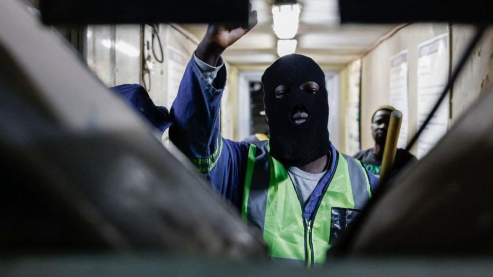 A mineworker gestures at the entrance of the Gold One Modder East operation mineshaft near Springs on October 24, 2023.