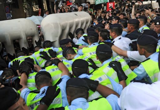 Hong Kong policemen push against a barricade holding back pro-democracy demonstrators calling on the Chinese government to investigate the death of dissident Li Wangyang during a protest. Hong Kong installs a new leader and marks 15 years of Chinese rule Sunday, at a time of strong anti-Beijing sentiment after visiting Chinese President Hu Jintao was targeted by angry protesters