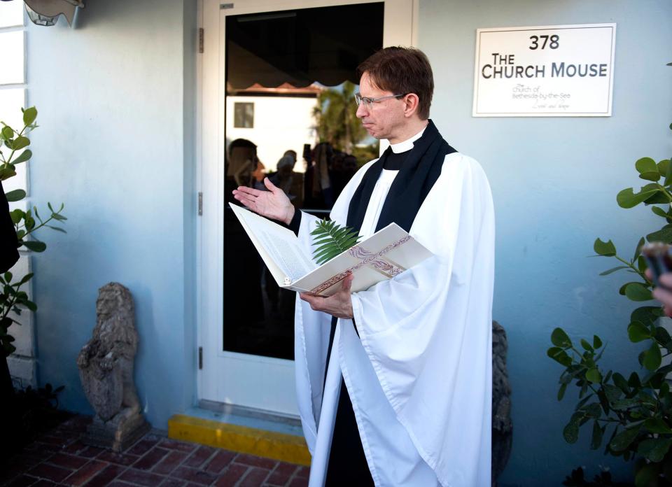 The Rev. Tim Schenck of The Episcopal Church of Bethesda-by-the-Sea blesses a pair of stone lions donated by Devonshire of Palm Beach at the front door of The Church Mouse on Wednesday.