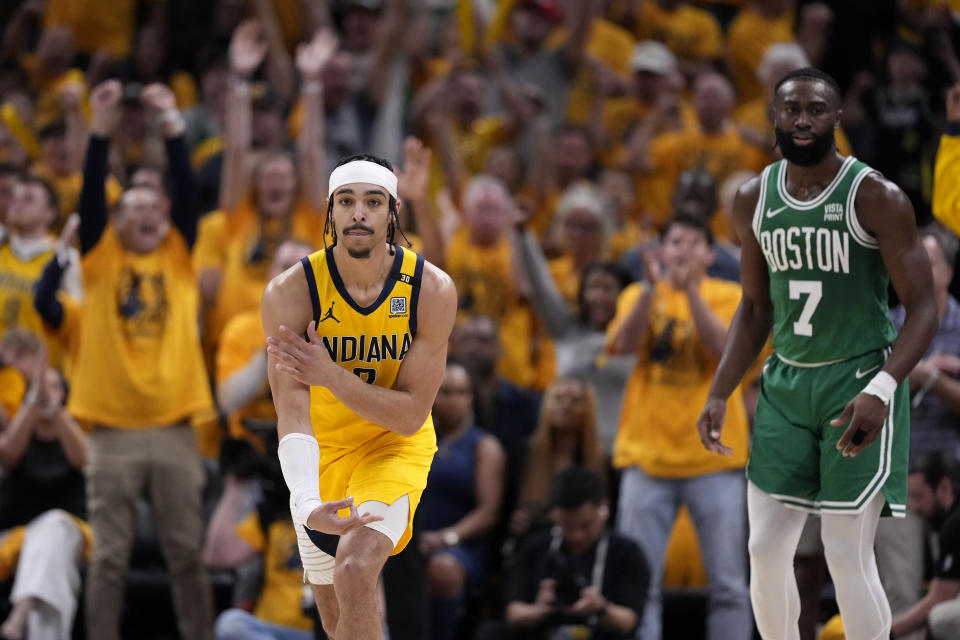 Indiana Pacers guard Andrew Nembhard celebrates in front of Boston Celtics guard Jaylen Brown (7) after making a three-point basket during the first half of Game 3 of the NBA Eastern Conference basketball finals, Saturday, May 25, 2024, in Indianapolis. (AP Photo/Michael Conroy)