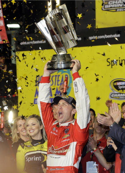 Kevin Harvick raises his trophy as he celebrates after winning the 2014 Sprint Cup championship. (AP)