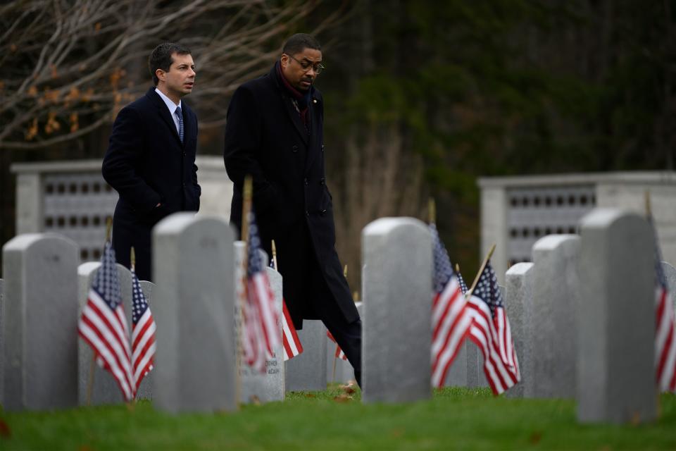 Democratic presidential hopeful Mayor Pete Buttigieg (L) walks through the New Hampshire State Veterans Cemetery in Boscawen, New Hampshire, on Nov. 11, 2019, with fellow veteran Thomas Gary, a senior petty officer at Naval Station Great Lakes, for a Veterans Day service as he continues his 4-day bus tour of the state. (Photo: Jim Watson/AFP via Getty Images)