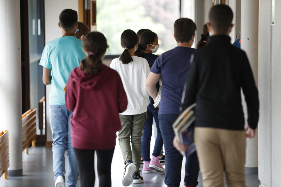 FILE - Schoolchildren walk back to their classroom after a break in Bischheim, outside Strasbourg, eastern France, Tuesday, Sept.1, 2020. The French government is unveiling a new plan on Wednesday Sept.27, 2023 to stop the bullying of children, amid growing concern about suicides by children whose families say they were targeted by bullying online or at school. (AP Photo/Jean-Francois Badias, File)