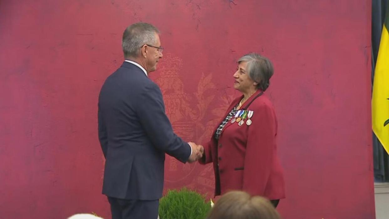 Saskatchewan Lieut. Gov. Russ Mirasty presents a 2023 Saskatchewan Volunteer Medal to Jyotsna (Jo) Custead Tuesday at Government House in Regina. (CBC News - image credit)