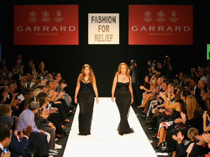 Princess Beatrice and Sarah Ferguson walk on a runway in a fashion show.
