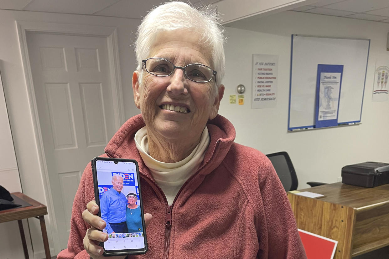 Lois Kessin, 73, holds a photograph of her with President Biden on her mobile phone, during a break in the monthly meeting of the Laconia, N.H., Democratic Committee, Thursday, March 2, 2023, in Laconia. Kessin says she's "very happy" with Biden. (AP Photo/Steve Peoples)