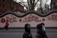 Pedestrians wearing face masks walk down the street in Beijing