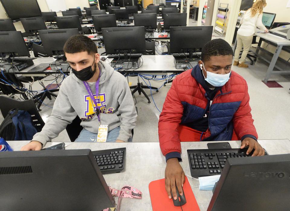 Erie High School seniors Latwon Ortiz, 18, left, and Daijour George, 17, work on a marketing project in an updated classroom on Thursday. New lighting and HVAC systems bring the classroom up to modern standards. Before the upgrades, Ortiz said, "We used to die in here it was so hot."