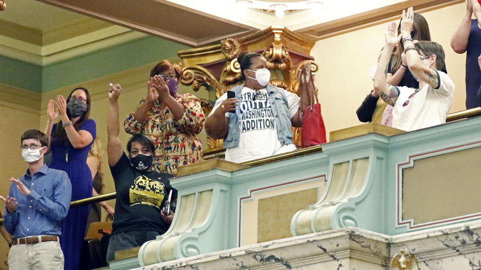 Members of the Mississippi Senate gallery rise and applaud after the body passed a resolution that would suspend the rules to allow lawmakers to change the state flag, Saturday, June 27, 2020 at the Capitol in Jackson, Miss. Members of both the House and Senate are now expected to pass a bill that removes the current flag and establishes a path forward to getting a new one. Gov. Tate Reeves has already said he would sign whatever flag bill the Legislature decides on. The current flag has in the canton portion of the banner the design of the Civil War-era Confederate battle flag, that has been the center of a long-simmering debate about its removal or replacement. (AP Photo/Rogelio V. Solis)