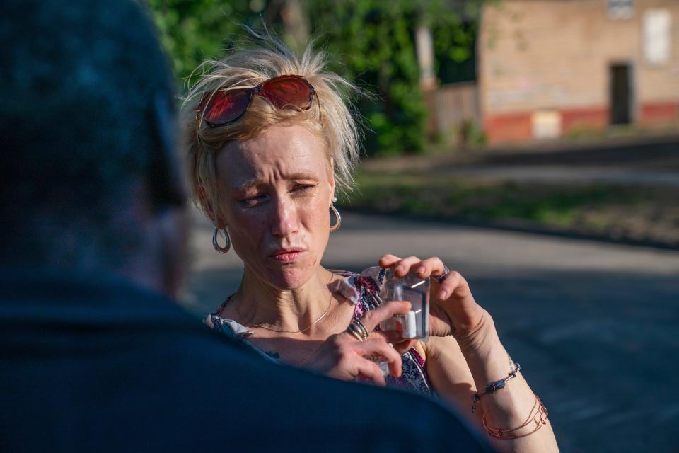 Amanda educates a passerby on the proper use of Narcan nasal spray on Friday, June 3, 2022, as she distributes harm reduction supplies around Detroit in places she knows where drug use is pervasive.