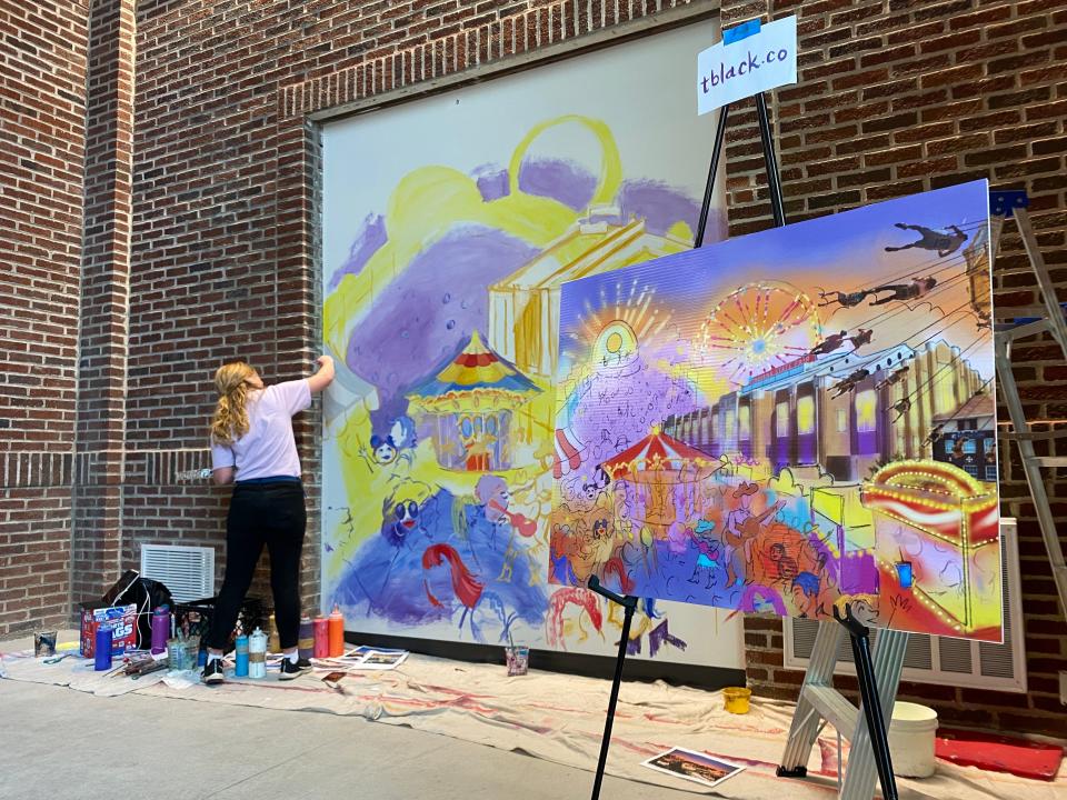 Tiffany Black begins painting a mural at the entrance to the Indiana Farm Bureau Fall Creek Pavilion at the Indiana State Fairgrounds. The facility was unveiled July 20, 2023. Black's mural theme is "music and entertainment" at the Indiana State Fair.