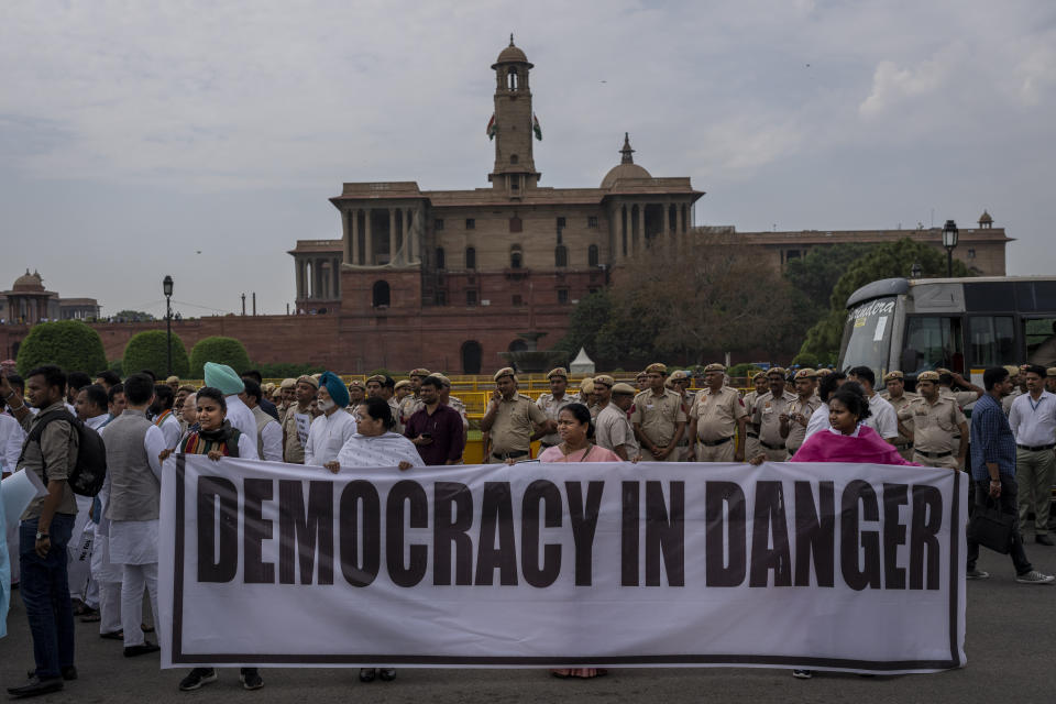 Lawmakers from India's opposition Congress and other parties hold a banner as they march against the Narendra Modi-led government alleging that Indian democracy is in danger, during a protest outside India's parliament in New Delhi, India, Friday, March 24, 2023. Key Indian opposition Congress party leader Rahul Gandhi lost his parliamentary seat as he was disqualified following his conviction by a court that found him of guilty of defamation over his remarks about Prime Minister Narendra Modi's surname, a parliamentary notification said on Friday. (AP Photo/Altaf Qadri)