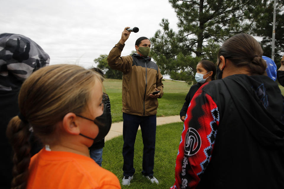 Lakota culture teacher Jason Drapeaux, Jr .gathers students at an assembly for Orange Shirt Day on Sept. 30, 2021, in Pine Ridge, S.D. Students and teachers wore orange in solidarity with Indigenous children of past generations who suffered cultural loss, family separation and sometimes abuse and neglect while compelled to attend hundreds of residential schools that once dotted the map across the United States and Canada from the late 19th to the mid-20th centuries. (AP Photo/Emily Leshner)