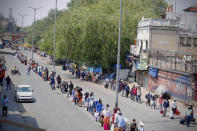 Indians line up to board trains outside New Delhi railway station in New Delhi, India, Tuesday, May 12, 2020. India is reopening some of its colossal rail network as the country looks at easing its nearly seven-week strict lockdown amid an increase in coronavirus infections. (AP Photo/Manish Swarup)