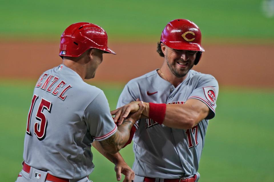 Cincinnati Reds' Nick Senzel (15) and Kyle Farmer (17) congratulate each other after they both scored on a single by Aristides Aquino during the first inning of a baseball game against the Miami Marlins, Tuesday, Aug. 2, 2022, in Miami.