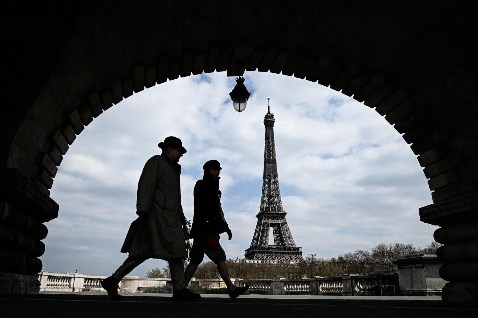 Paris: Passanten gehen auf der Brücke «Pont de Bir-Hakeim», mit Blick auf den Eiffelturm. Foto: Philippe Lopez / AFP / dpa