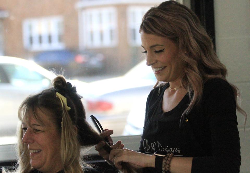 Kallie Clossman is the owner of KalClo Designs Hair & MakeUp Studio in downtown Newark. She colors the hair of her aunt Regina Simons last Wednesday.