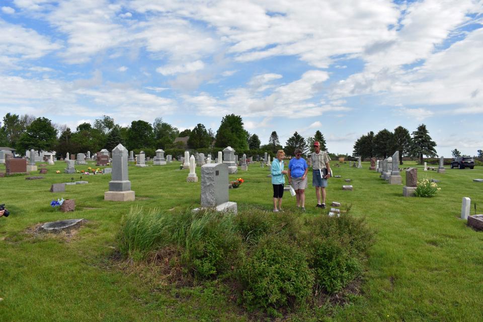 Barb Mallon, Joan Schoon and Dennis Mitchell inspect the progress of the project to clean and repair headstones at Bethlehem Lutheran Church Cemetery in Slater.